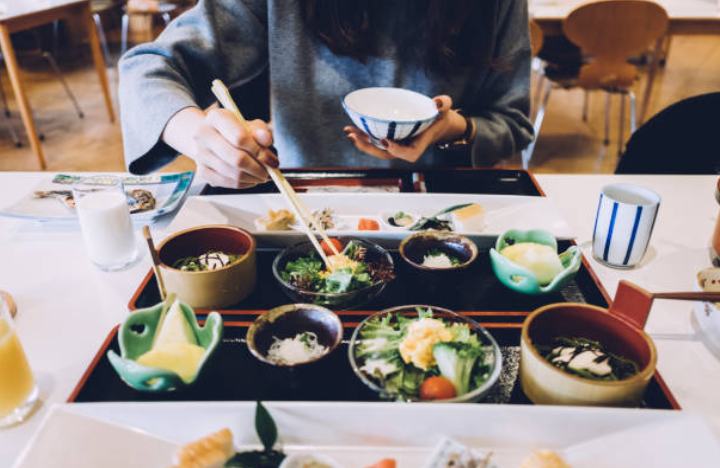 repas-japon-table-bols-baguettes-plats-algues-riz-condiments-cru-cuit